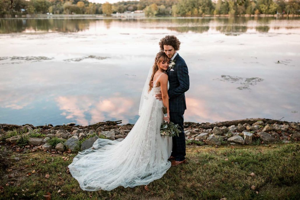 Bride and groom in front of lake