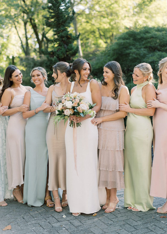 Abby and her bridesmaids in pastel mix and match gowns that match her bridal bouquet