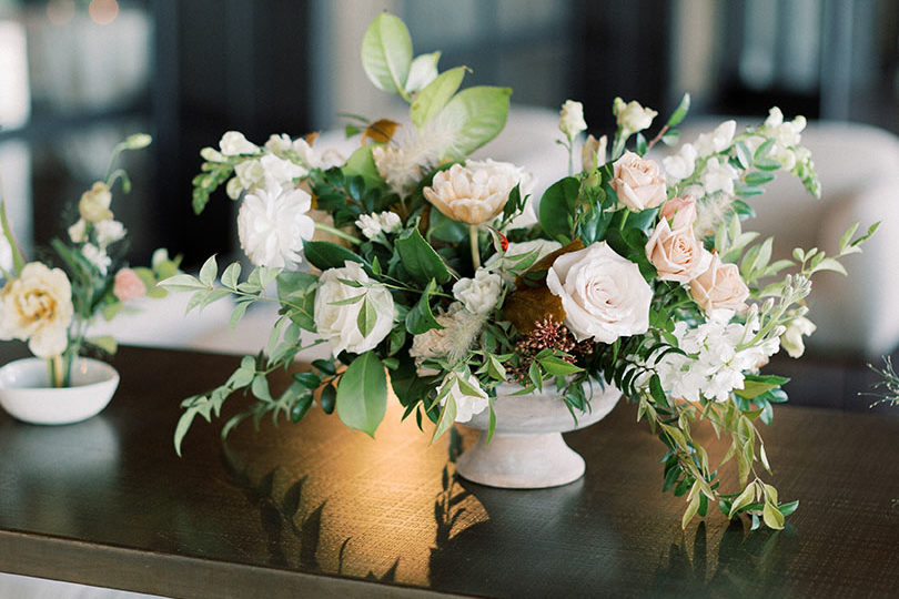 table floral arrangement with white roses and greenery