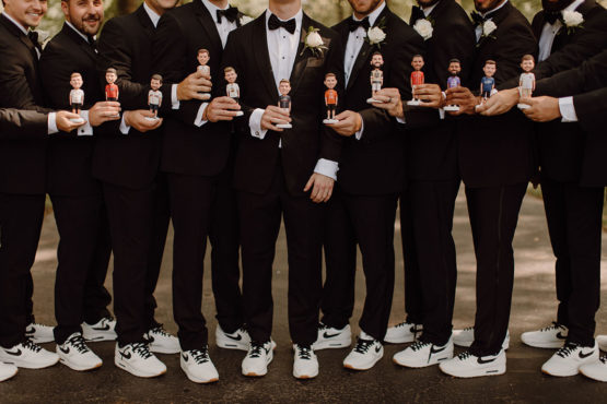 Groomsmen in classic tuxedos with matching white Nike Airmax and customized bobbelheads