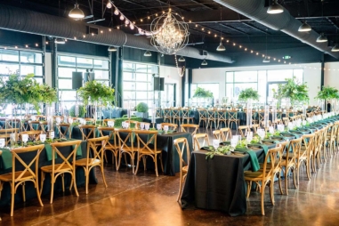 Wedding reception setup in Lakeview Event Center with dark linens and greenery decor