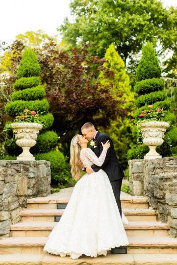 Andrea and Trevor kiss on the stairs of the serenity gardens