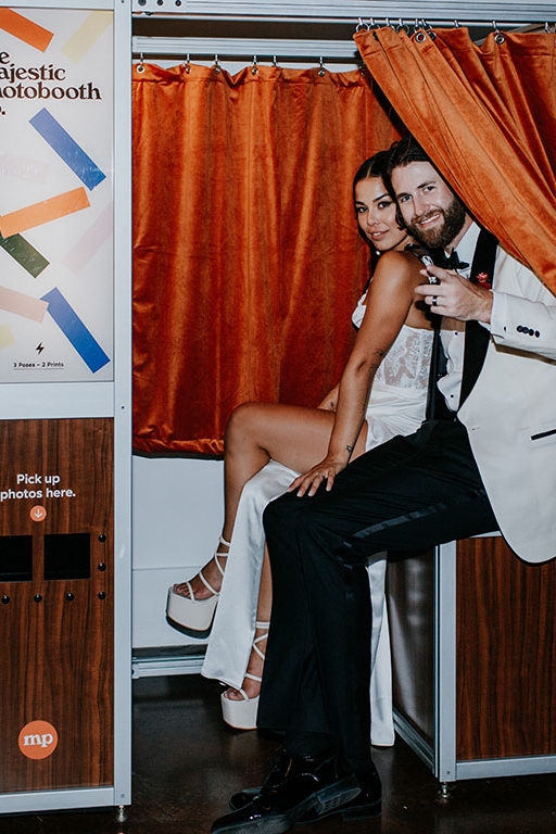 bride and groom pose in a retro photo booth
