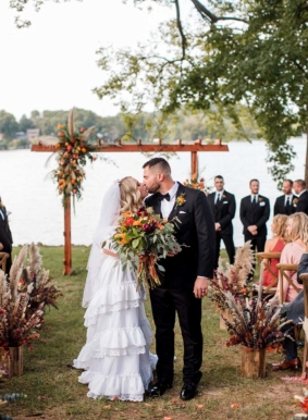 Bride and groom kissing during wedding recessional