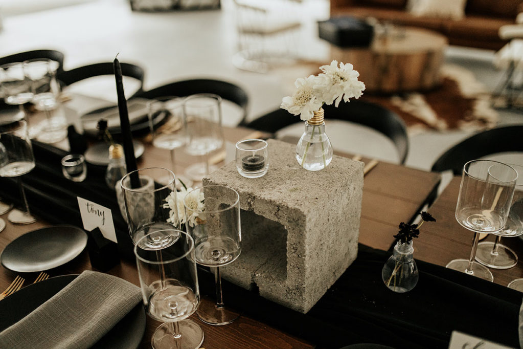 Modern eclectic wedding reception decor with cement block and light bulb vases