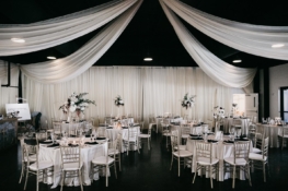 Romantic Wedding Reception Setup in the Lakeview Event Cente with white drapery and silver chairsr