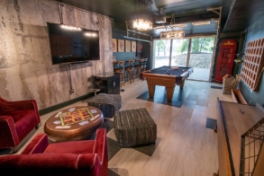 Arcade and game room with pool table, shuffleboard, large TV, games, darts, and cards