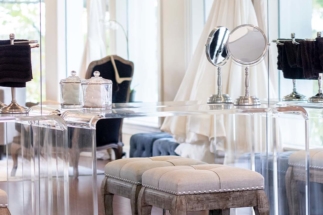 Wall of mirrors with acrylic makeup tables and stools in mansion's bridal suite