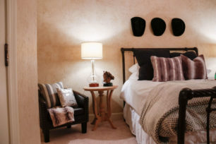 Garth Brooks themed bedroom inside the Mansion with black iron bedframe and cowboy hats hung on the wall