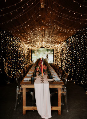 Rehearsal Dinner Table in Carriage House Stables surrounded by a canopy of string lights