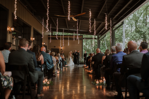 Bride and groom during ceremony on Lakeview Event Center's patio with string light strips hanging above