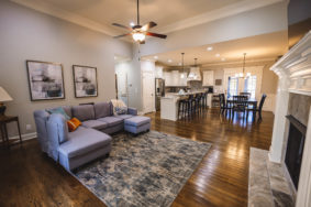 Open concept living room with fireplace, dining room, and kitchen inside Gatehouse 135