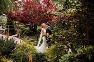 Bride and groom kiss in Serenity Gardens