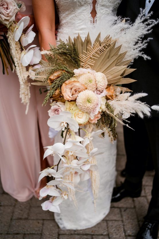 Large boho bridal bouquet with hanging florals, white orchids, dried leaves, and earthy pastel blooms