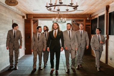 Groom and groomsmen walking through Carriage House Stables