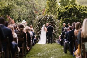Wedding Ceremony in Serenity Gardens with wild greenery arch