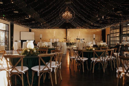 Canopy of string lights over wedding reception table setup inside Lakeview Event Center