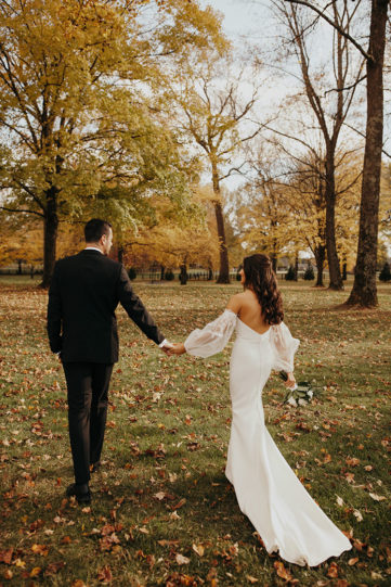 jessica and ben holding hands under the fall foiliage