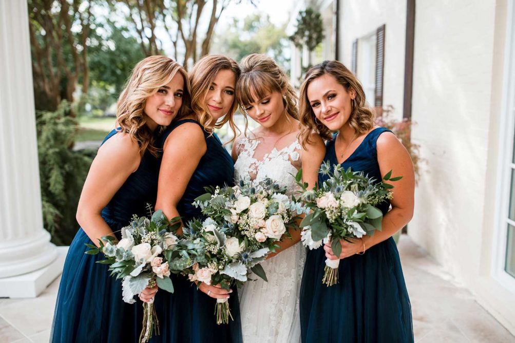 Bride with bridesmaids on mansion's front steps
