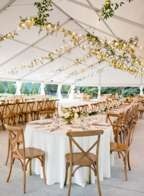 Wedding reception setup on Sunset Terrace with wooden chairs, white linens, and greenery decor