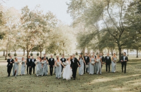 Bride and groom with large wedding party under Willow Oak Canopy