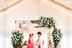 Traditional Indian bride and groom standing in front of mandap