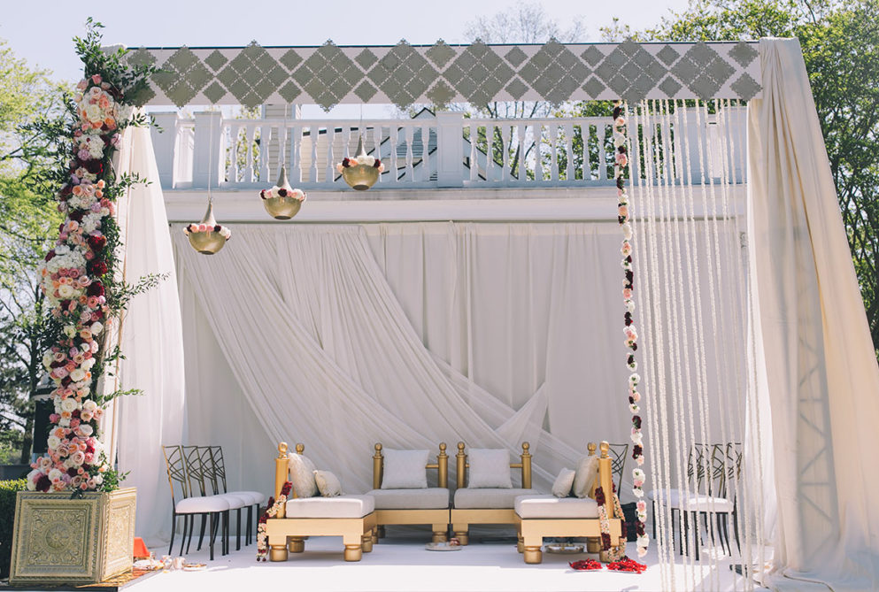 Traditional Indian wedding mandap with white and gold seating