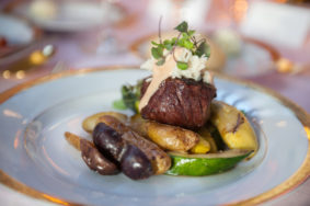 Wedding catering photo of plated sirloin with fingerling potatoes, squash, and zuccini