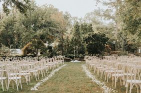 Ceremony setup next to Serenity Gardens with white chairs and petal-lined aisle