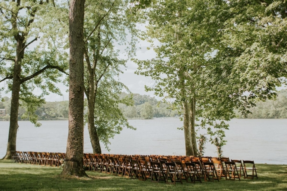 Wedding ceremony setup across Lakeside Lawn with brown chairs and freestanding floral arrangements as backdrop