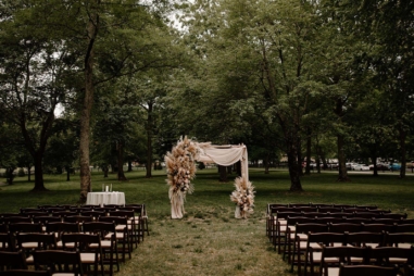 Ceremony setup under Willow Oak Canopy with drapery and boho floral arrangements on ceremony arch